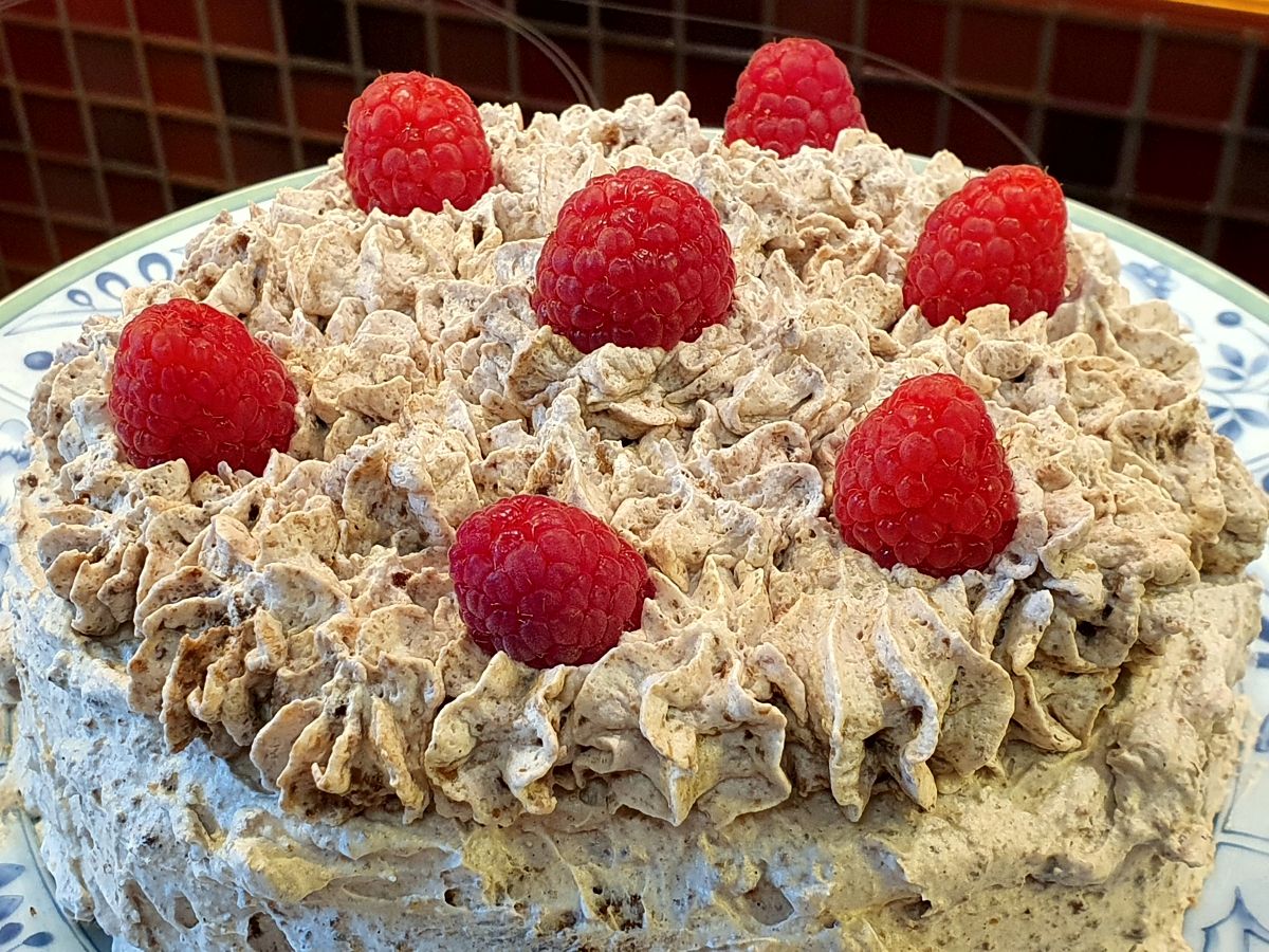 Schokoladen-Mandeln-Sahne-Torte mit Himbeeren garniert