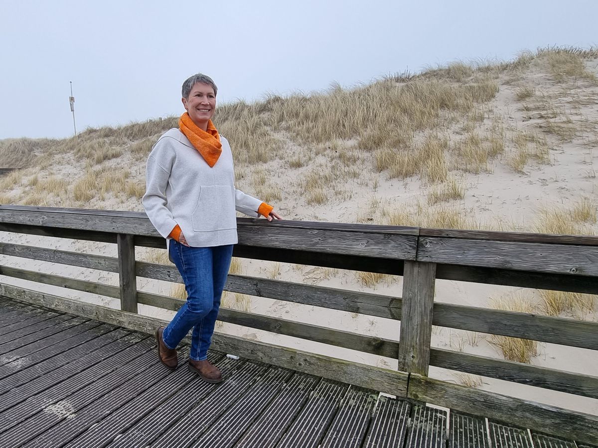 Ines-Meyrose - Outfit 2022 - heller Strickhoodie mit Eingrifftasche kombiniert mit Loop und Stulpen in Orange - High Class Leger Chic - Ü50 Bloggerin