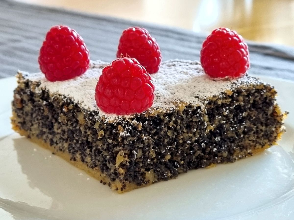 Mohnkuchen mit Puderzucker und Himbeeren