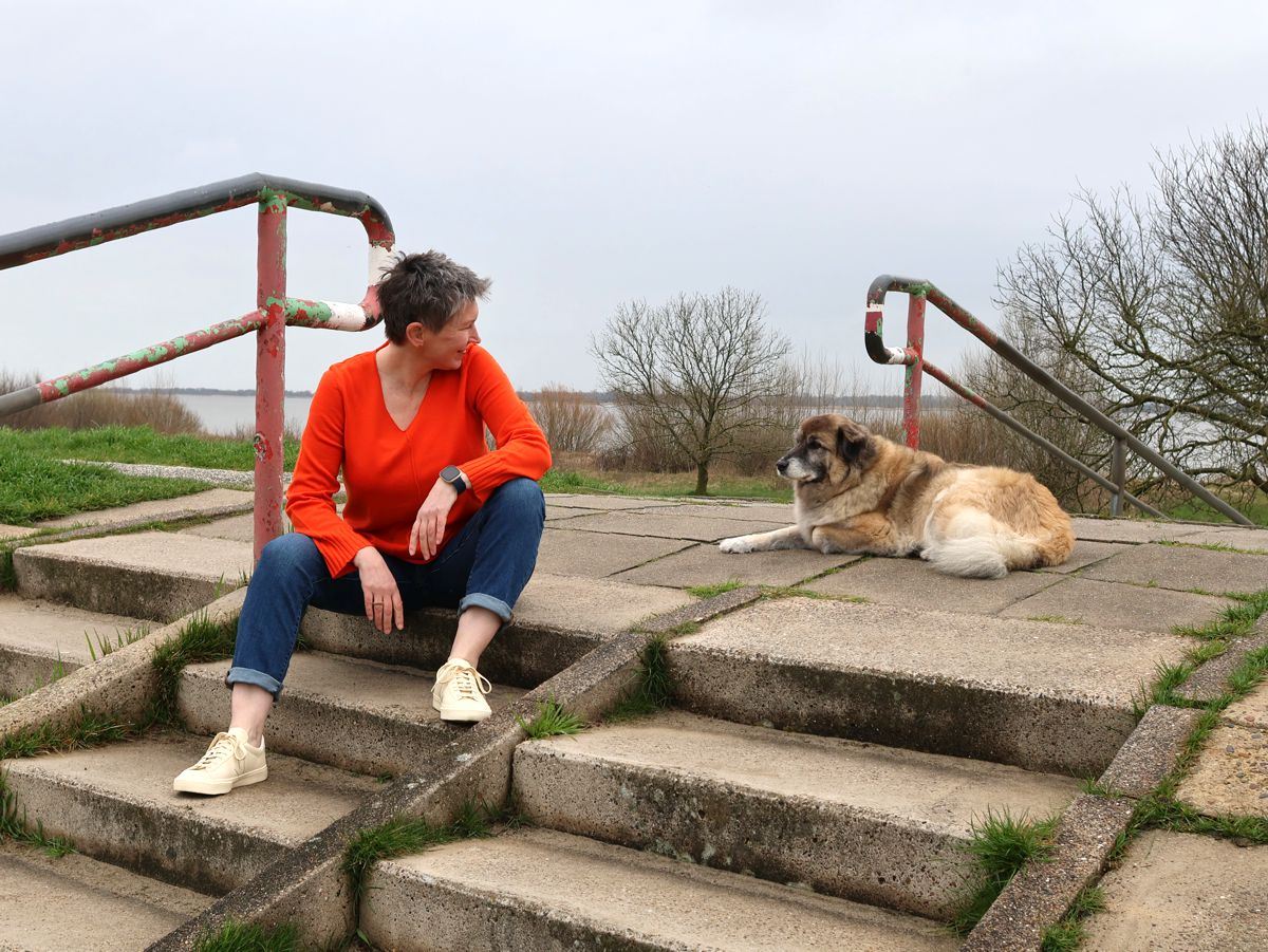 Ines Meyrose - Outfit 2023 - Jeans, Pullover Orange, Sneaker Creme mit Bloggerhund Paul