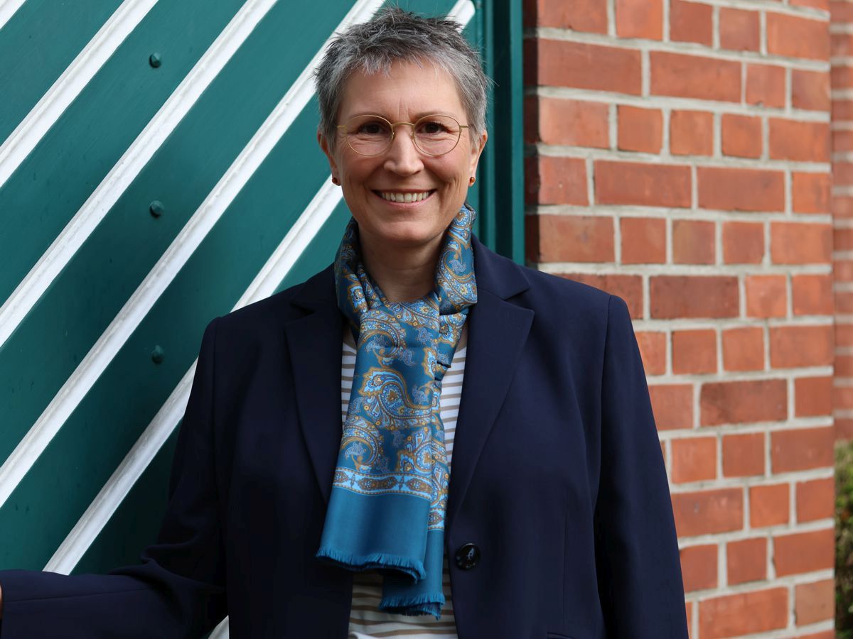 Ines Meyrose - Outfit 2023 mit dunkelblauem Blazer, blauer Jeans mit leichter Waschung, Ringelshirt in Hellbraun-Natur und Seidenschal in Petrol mit Paisleymuster - Farbklammer Braun und Blau - Portrait - Foto Nicole