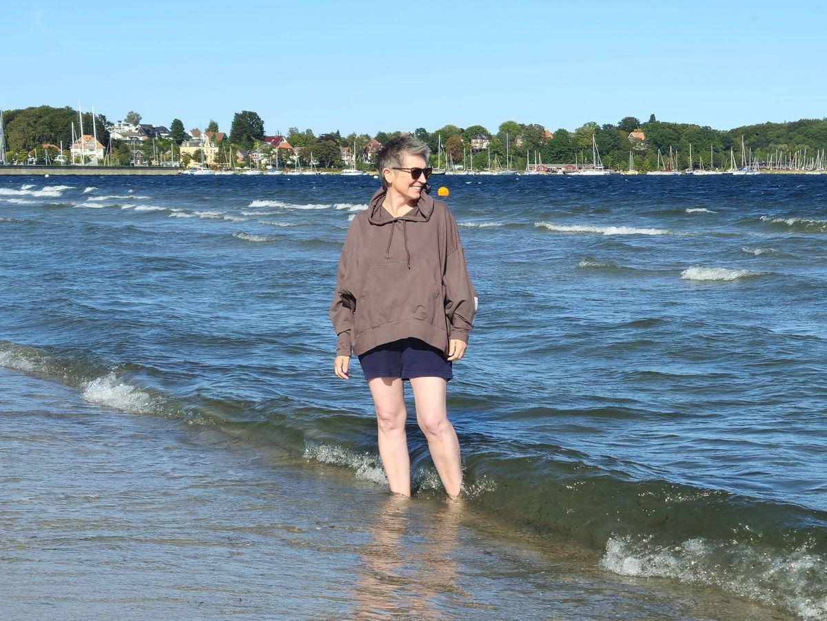 Ines Meyrose - Outfit 2025 - Hoodie braun und Shorts am Strand