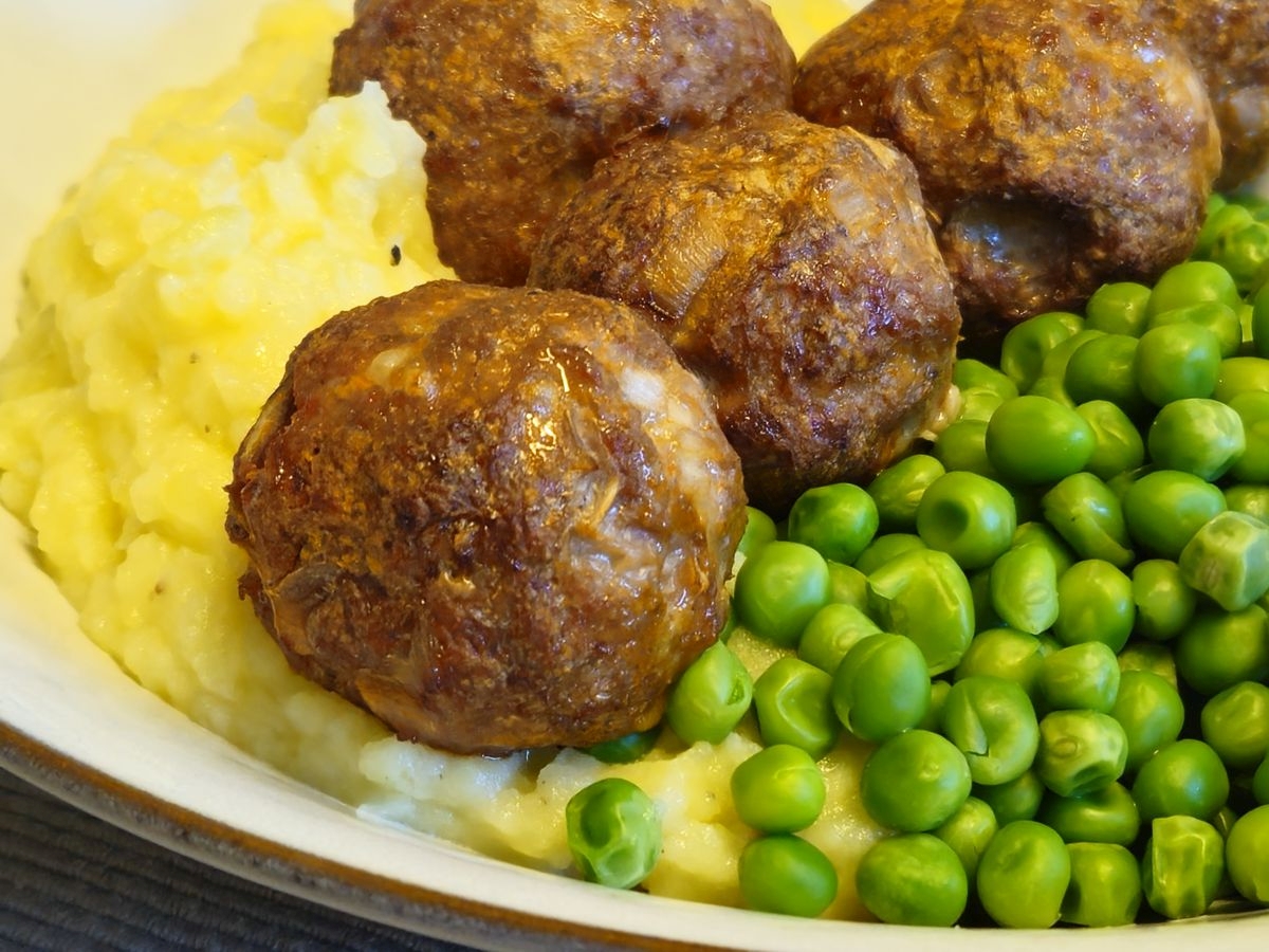 Hackbällchen aus dem Ofen mit Kartoffelpürree und extrafeinen Erbsen